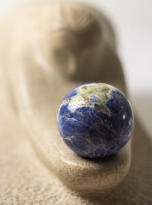 Limestone sculpture called "The Gift" carved in Indiana limestone in 2016 and including a Lapis Lazuli sphere. Frontal view with focus on the sphere.
